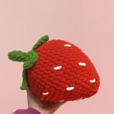 crochet strawberry on hand