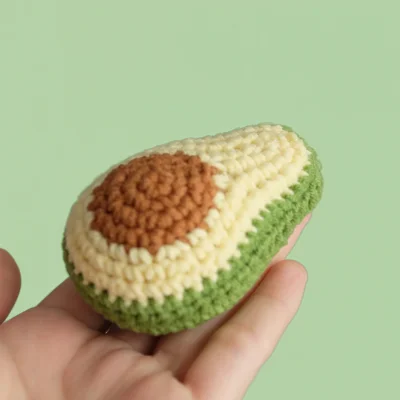 crocheted avocado in hand