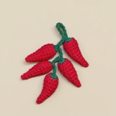 crochet chili peppers on light background