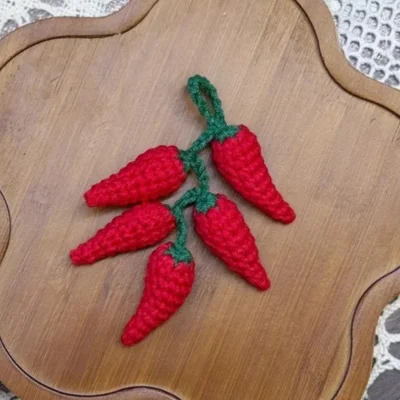 crochet chili peppers on wooden tray